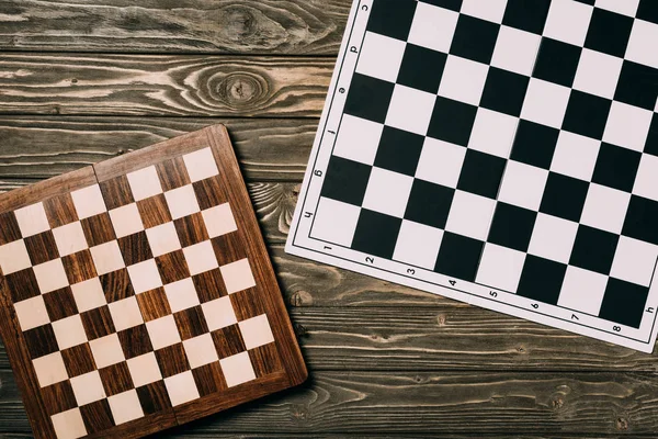 Vista superior de dos tableros de ajedrez sobre fondo de madera texturizada - foto de stock