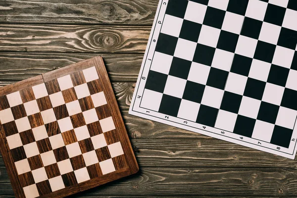 Top view of two chessboards on textured wooden background — Stock Photo