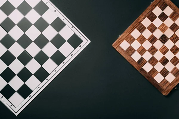 Top view of checkerboards isolated on black — Stock Photo