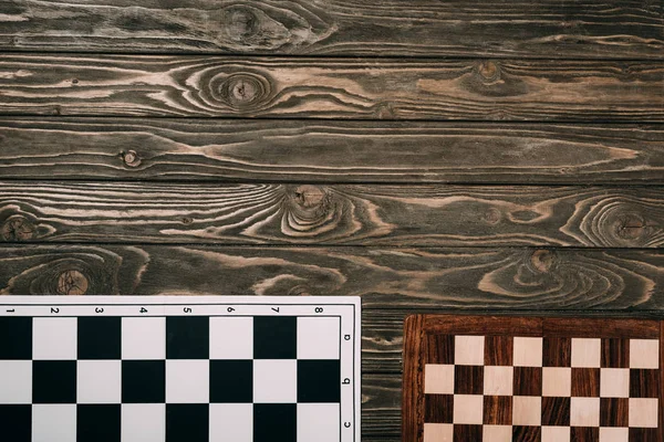 Top view of two checkerboards on wooden background with copy space — Stock Photo