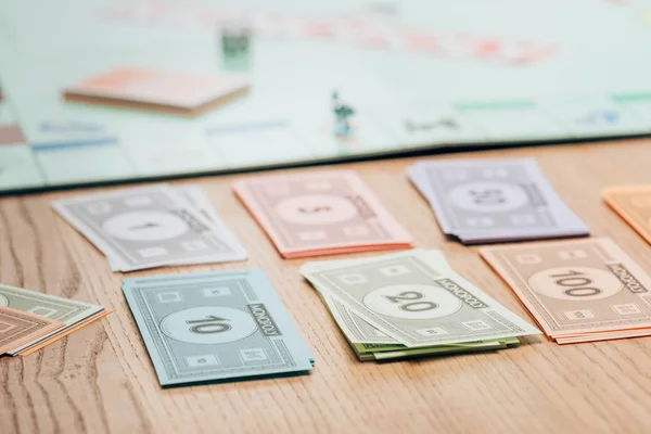 KYIV, UKRAINE - NOVEMBER 15, 2019: Selective focus of toy currency with monopoly game on wooden table — Stock Photo