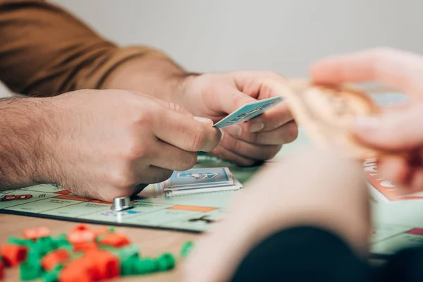 KYIV, UKRAINE - NOVEMBER 15, 2019: Selective focus of man and woman playing monopoly game — Stock Photo