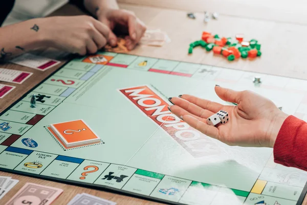KYIV, UCRAINA - 15 NOVEMBRE 2019: Vista ritagliata della donna che gioca al gioco del monopolio a tavola — Foto stock