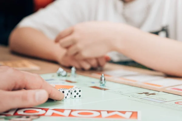 KYIV, UKRAINE - NOVEMBER 15, 2019: Selective focus of man and woman playing monopoly game at table — Stock Photo