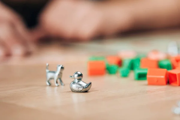 KYIV, UKRAINE - NOVEMBER 15, 2019: Selective focus of playing figures of monopoly game on wooden table — Stock Photo