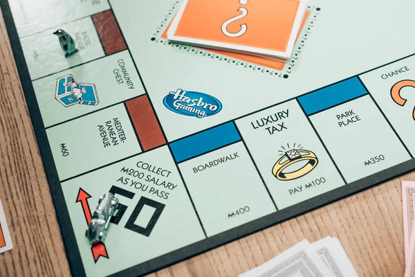 KYIV, UKRAINE - NOVEMBER 15, 2019: Monopoly board game with cards on wooden table — Stock Photo