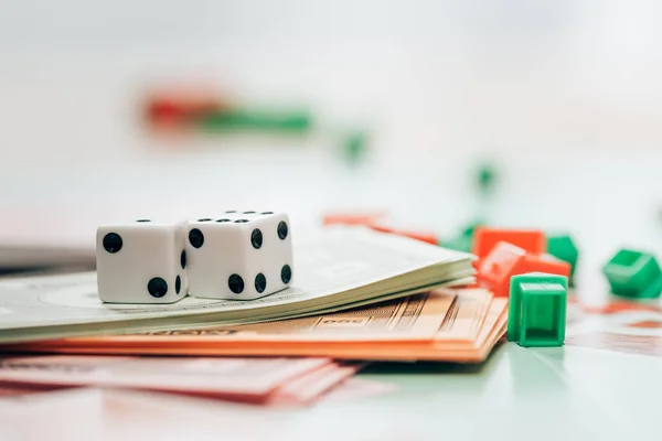 KYIV, UKRAINE - NOVEMBER 15, 2019: Selective focus of dices, toy currency and figures on monopoly game — Stock Photo