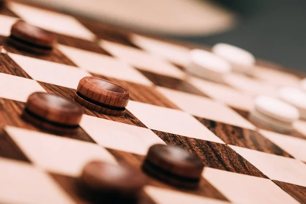 Selective focus of wooden checkers on chessboard — Stock Photo