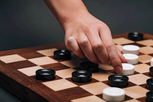 Vista recortada de la mujer jugando damas sobre fondo gris - foto de stock