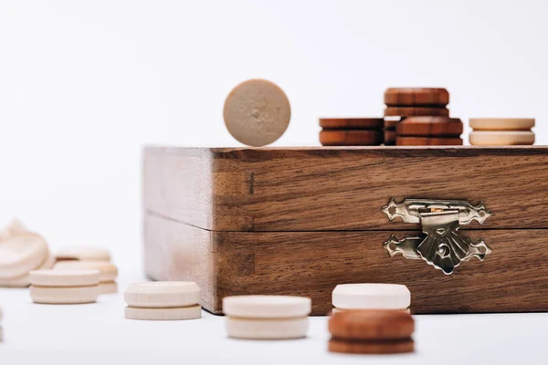 Enfoque selectivo de damas blancas y marrones en tablero de ajedrez de madera aislado en blanco - foto de stock