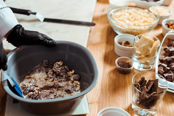 Vista ritagliata di cioccolato miscelazione gocce di cioccolato in ciotola — Foto stock