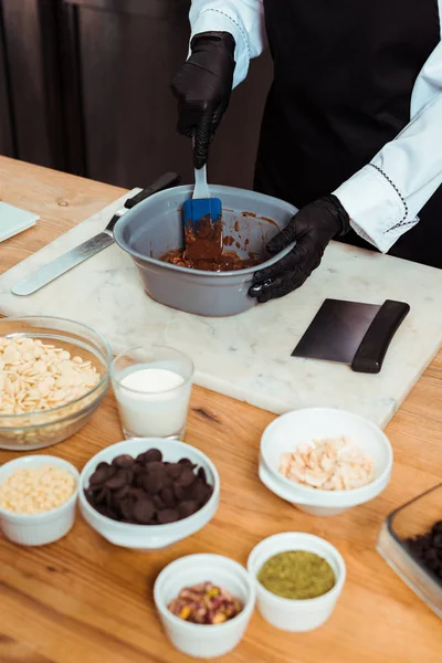 Zugeschnittene Ansicht eines Chocolatiers mit Silikonspachtel beim Mischen von Schokolade in einer Schüssel — Stockfoto