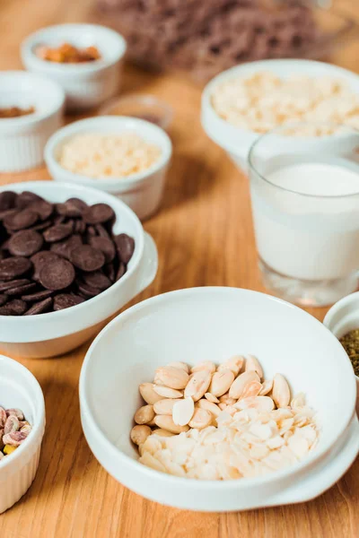 Selective focus of nuts in bowl near chocolate — Stock Photo