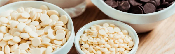 Colpo panoramico di gocce di cioccolato bianco in ciotole — Foto stock