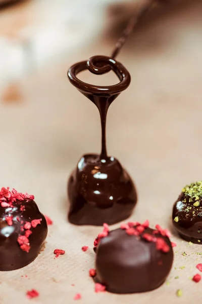 Close-up de framboesas secas e pó de pistache em bolas de chocolate feitas na hora — Fotografia de Stock