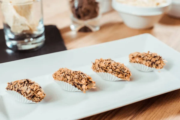 Selektiver Fokus der zubereiteten Schokoladenbonbons mit Flocken auf dem Teller — Stockfoto