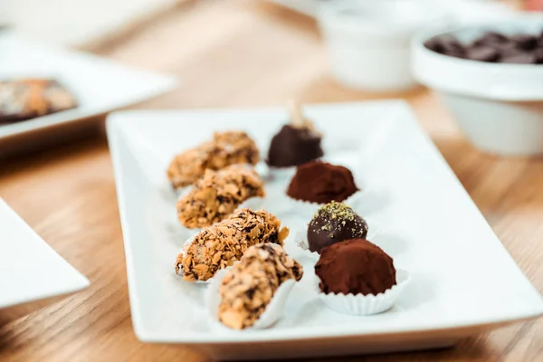 Selektiver Fokus von Schokoladentrüffeln und leckeren Bonbons auf dem Teller — Stockfoto