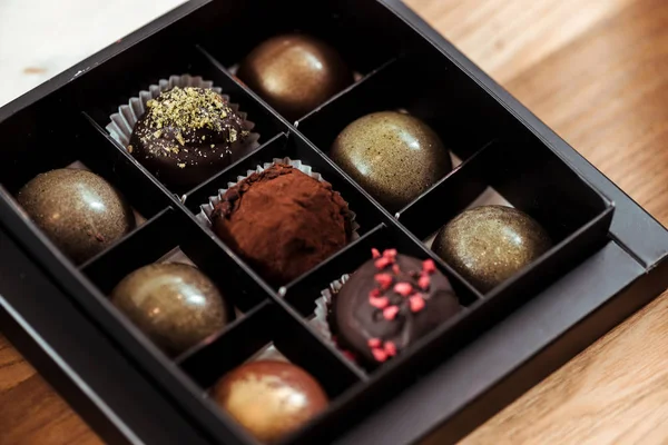 Deliciosas bolas de chocolate con frambuesas secas y pistacho en polvo en caja - foto de stock