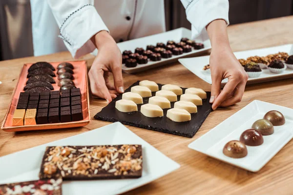 Vue recadrée de plaque tactile chocolatier avec de savoureux bonbons au chocolat blanc — Photo de stock