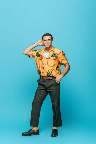 Handsome dancer looking at camera while dancing boogie-woogie on blue background — Stock Photo