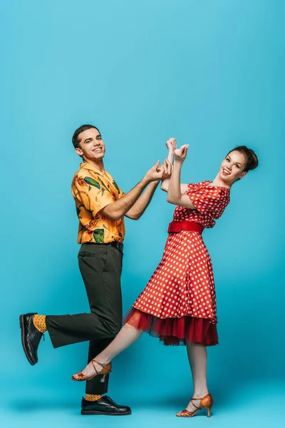 Danseurs élégants claquer des doigts tout en dansant boogie-woogie sur fond bleu — Photo de stock