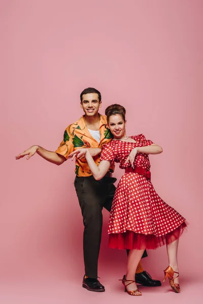 Danseurs élégants regardant la caméra tout en dansant boogie-woogie sur fond rose — Photo de stock