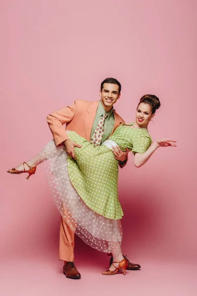Elegante Tänzerin unterstützt Mädchen beim Tanzen von Boogie-Woogie auf rosa Hintergrund — Stockfoto