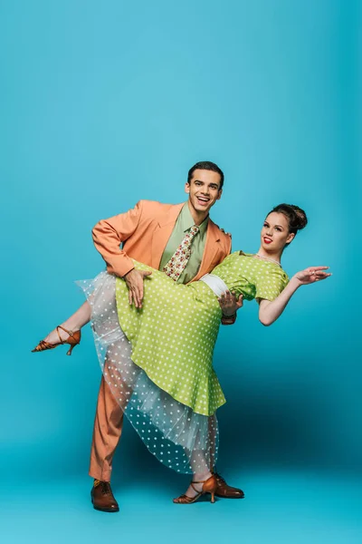 Bonito dançarino apoio menina enquanto dança boogie-woogie no fundo azul — Fotografia de Stock