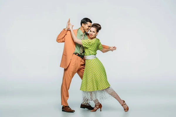 Danseurs élégants tenant la main tout en dansant boogie-woogie sur fond gris — Photo de stock