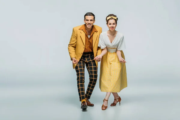 Elegant dancers looking at camera while dancing boogie-woogie on grey background — Stock Photo