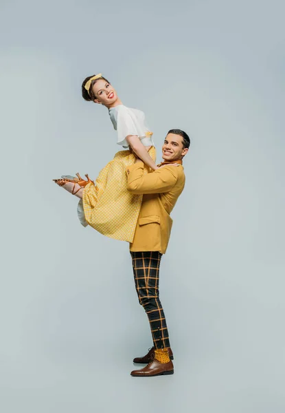 Happy dancer holding girl while dancing boogie-woogie on grey background — Stock Photo