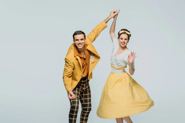 Happy dancers holding hands while dancing boogie-woogie on grey background — Stock Photo