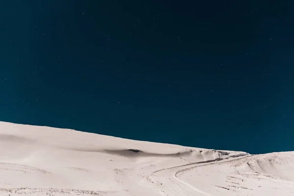 Vista panorámica de la montaña cubierta de nieve pura contra el cielo azul oscuro - foto de stock