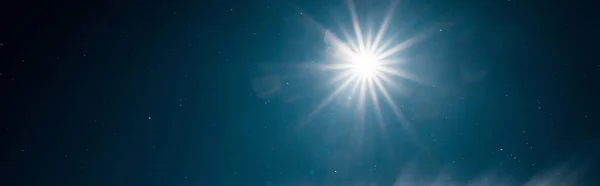 Мальовничий вид на яскраве сонце, що сяє в чистому темно-синьому небі, панорамний знімок — стокове фото
