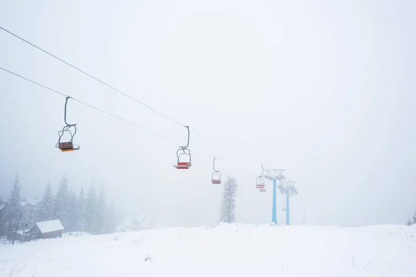 Vue panoramique sur la montagne enneigée avec télécabine dans le brouillard — Photo de stock