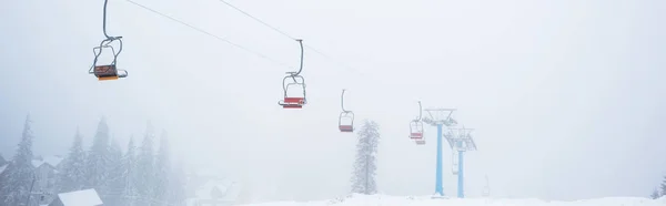 Vista panoramica della montagna innevata con cabinovia in nebbia, colpo panoramico — Foto stock