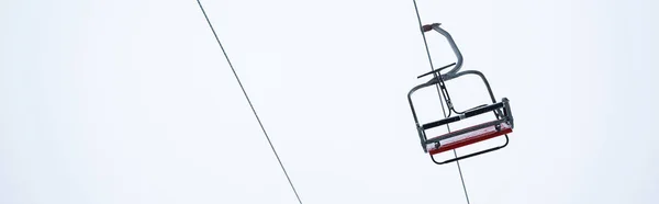 Siège de levage de gondole sur fond de ciel blanc pur, panoramique — Photo de stock