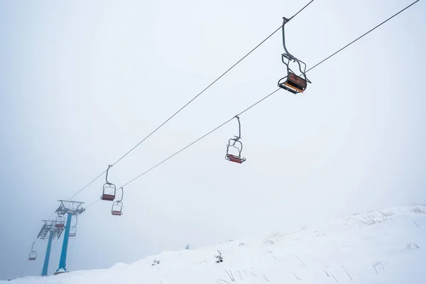 Vista panorâmica da montanha nevada com elevador de gôndola no nevoeiro — Fotografia de Stock