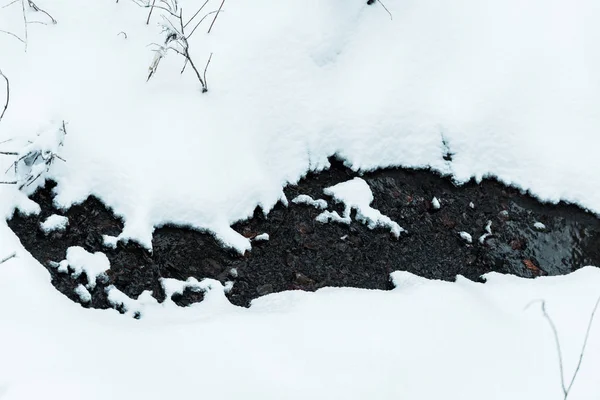 Vista superior del pequeño arroyo de agua que fluye en las montañas nevadas - foto de stock