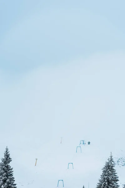 Vue panoramique sur la télécabine dans les montagnes enneigées avec des pins — Photo de stock