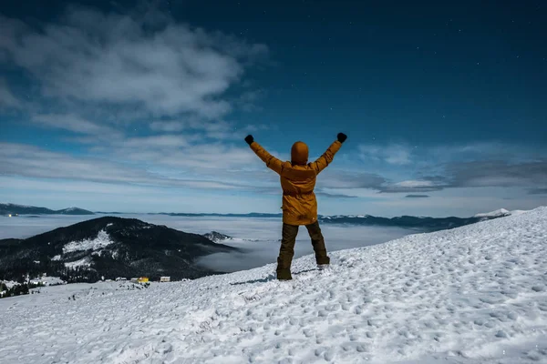 Vista posteriore di uomo eccitato in piedi con le mani sopra la testa in montagna — Foto stock