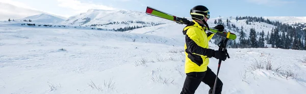 Tiro panorâmico de esquiador andando com paus em montanhas — Fotografia de Stock