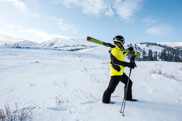 Профиль лыжника ходьба с палками в горах — стоковое фото