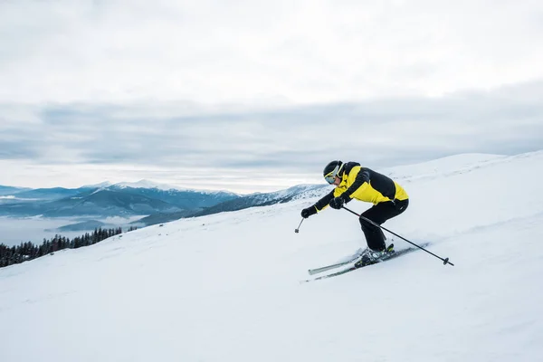 Homme athlétique en casque et lunettes de ski sur piste — Photo de stock