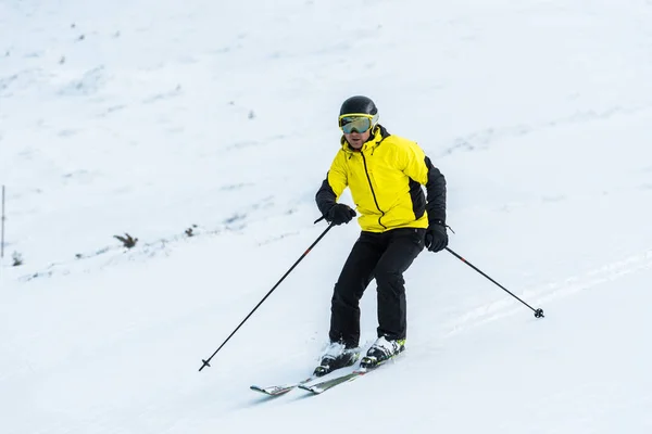 Esquiador sosteniendo palos y esquiando en la pista con nieve - foto de stock