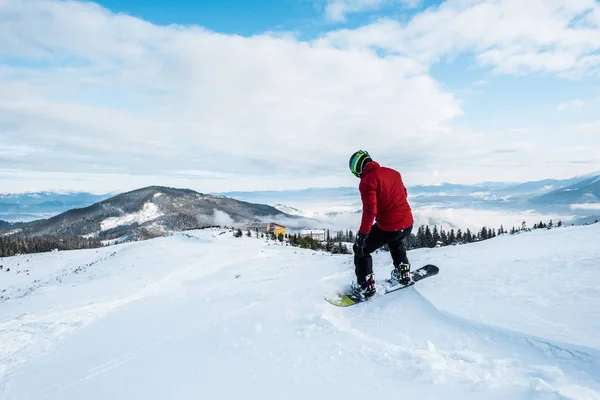 Snowboarder no capacete montando na encosta no inverno — Fotografia de Stock