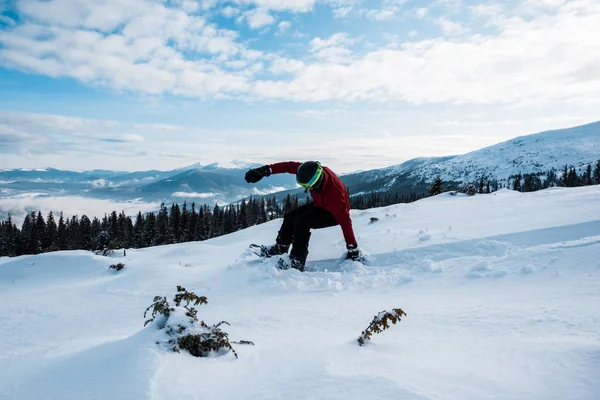 Snowboarder tomber tout en montant sur la pente dans les montagnes — Photo de stock