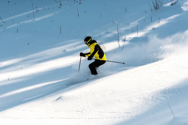 Sportsman in goggles holding ski sticks while skiing on snow — Stock Photo