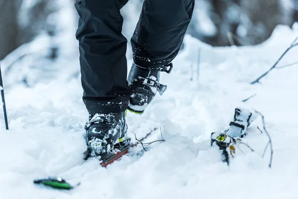 Vue recadrée du skieur en marchant sur la neige près des skis en hiver — Photo de stock