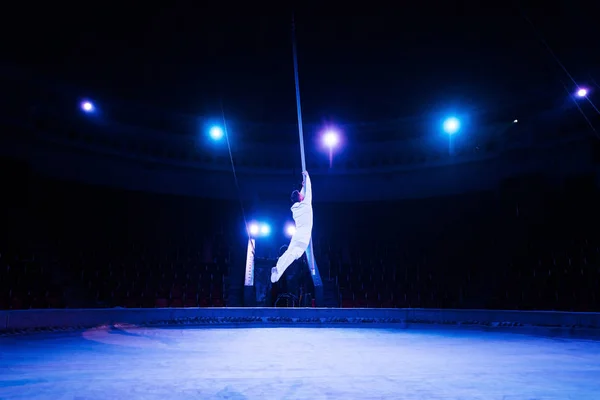 Luz azul perto acrobata atuando na arena do circo — Fotografia de Stock